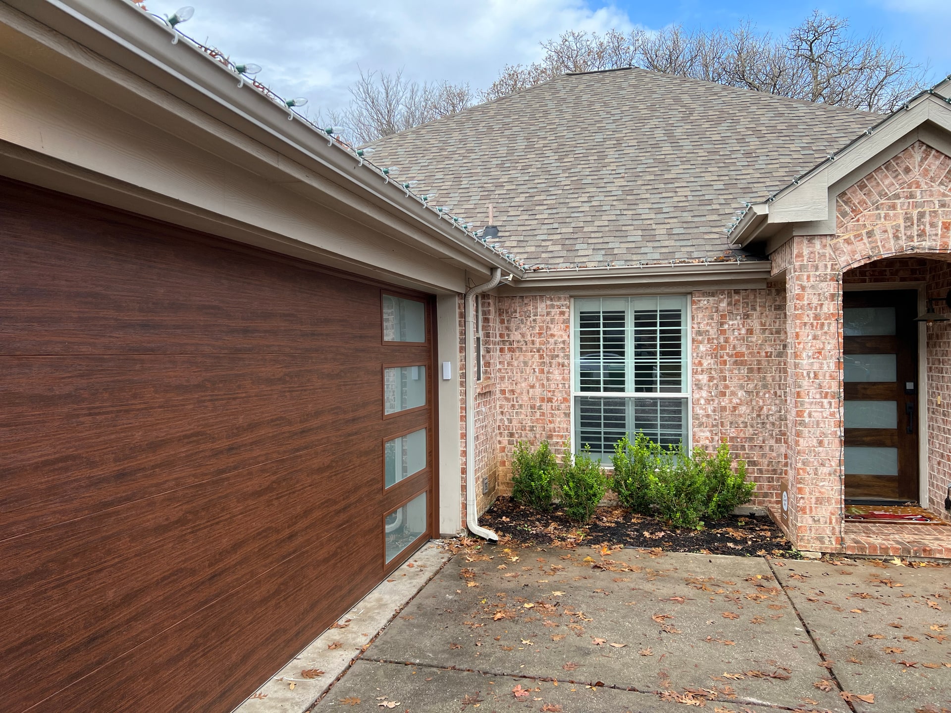 Wood-look residential garage door and matching home exterior